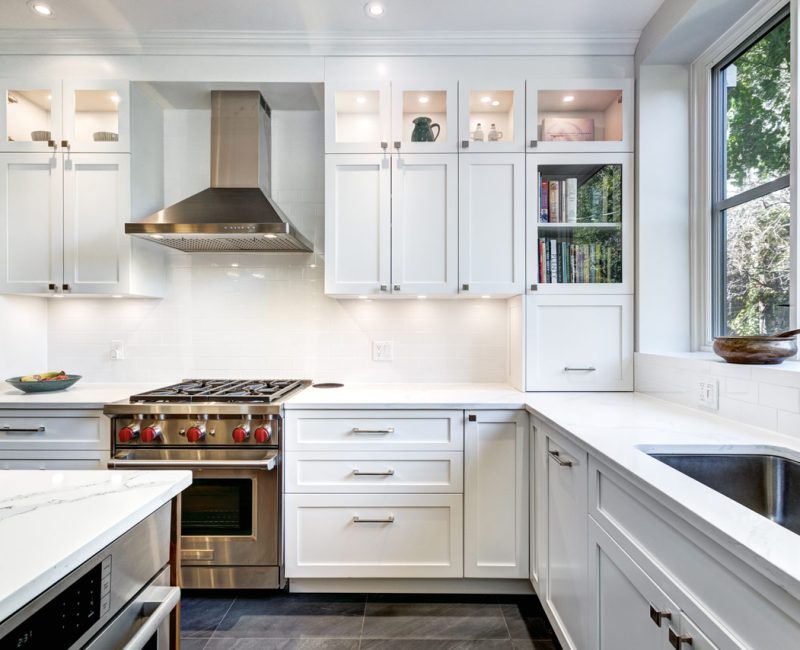 Kitchen Interior with stove range and oven, an exhaust hood, white cabinets with recessed lights